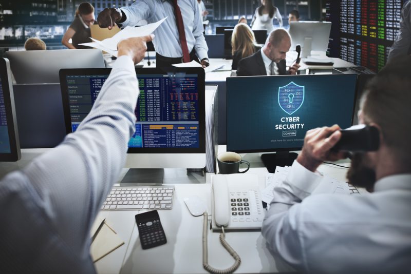 two person infornt of computer screen with text cybersurity